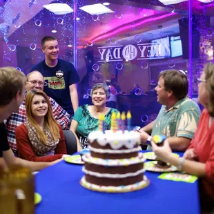 a group of people gathered around a cake