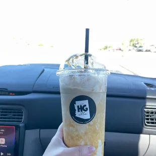 a hand holding a cup of iced coffee