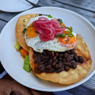 Huevos Rancheros - tostadas, chile-braised black beans, salsa, sunny side eggs, sweet potato hash, avocado, pickled red onions &amp; cilantro