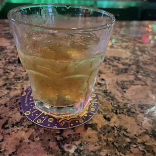 a drink in a glass on a coaster