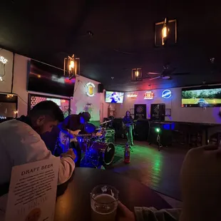 a man sitting at a bar drinking a beer
