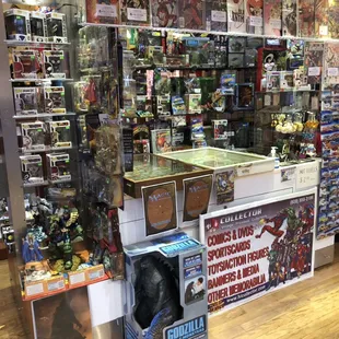 Funko pops, GI Joe's, Godzilla, Barbies, Comics, Star Wars, Pokemon and more! Looks like the kiosk is a mini version of the store!