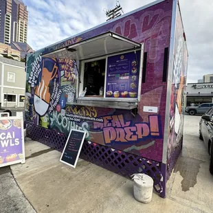 a purple food truck with graffiti on it