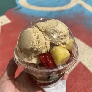 a hand holding a cup of ice cream