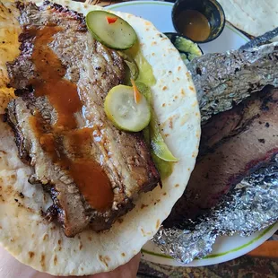 Brisket, eaten with tortillas, pickled items, bbq sauces