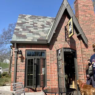 a man and his dog in front of a brick building