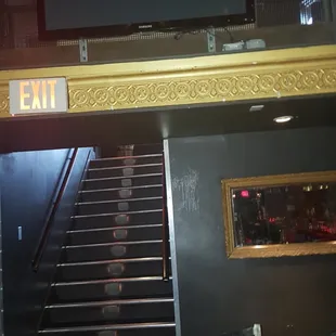 Take the stairs downward toward the bar inside of a pit!