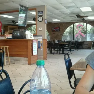 a woman sitting at a table with a bottle of water