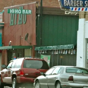 cars parked in front of a barber shop