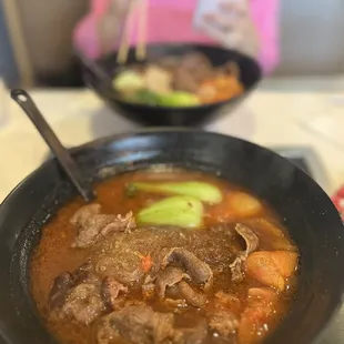 a bowl of stew with a spoon in it