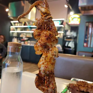 octopus skewered on a stick in a restaurant
