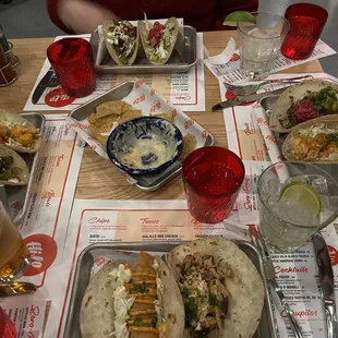 a table full of tacos and drinks