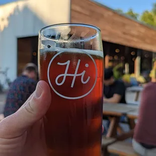 a person holding a glass of beer