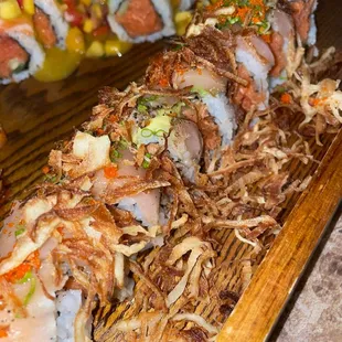a variety of sushi rolls on a wooden platter