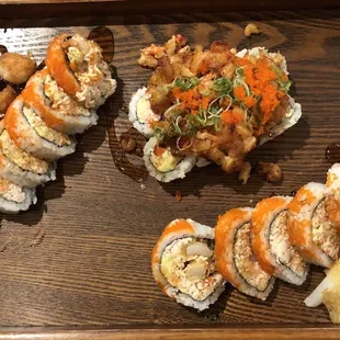 a variety of sushi on a wooden tray