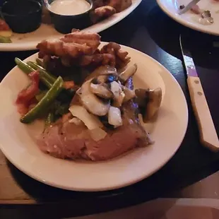 Prime rib dinner, mushroom and onion topping, cooked veggies on the side.. The 16 oz prime rib came on a big plate, e cut a bit off for me.