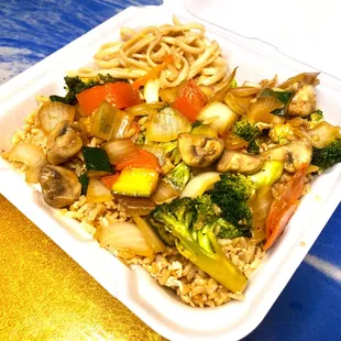  close up of a takeout container with noodles and vegetables