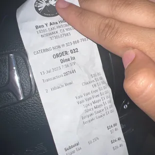 a hand holding a receipt