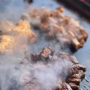 steaks cooking on a grill