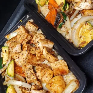 two trays of chicken and vegetables