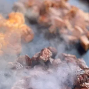 steaks cooking on a grill