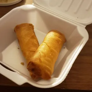 two fried food items in a styrofoam container
