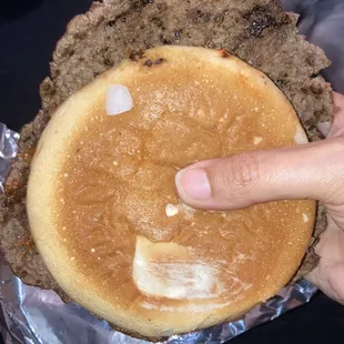 a person holding a hamburger pie