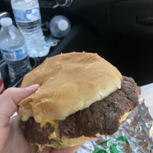 a hand holding a hamburger