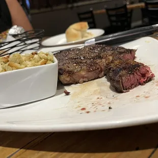 a steak with a side of macaroni and cheese