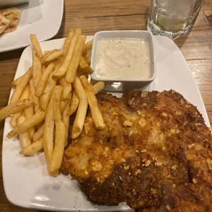 Chicken fried steak with gravy on the side.