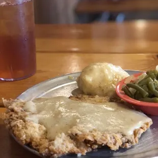 This my friends is a small chicken fried steak!  I cannot finish it!  Mashed potatoes and gravy and green beans.