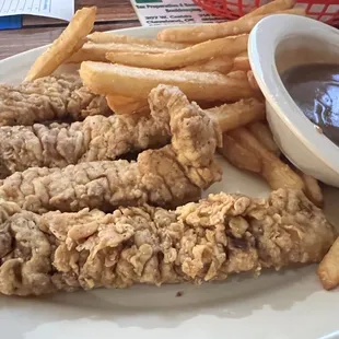 Steak Fingers and Fries with a side of brown gravy.