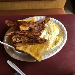 bacon, eggs, and toast on a paper plate