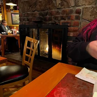 a woman sitting in front of a fire place