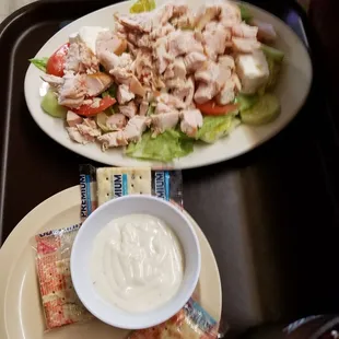 a plate of chicken salad and a bowl of ranch dressing