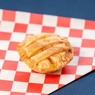 a pastry on a red and white checkered napkin
