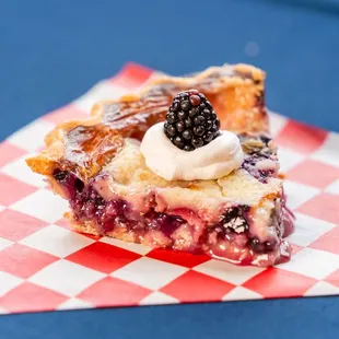 a blackberry pie with whipped cream