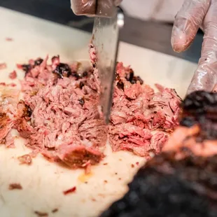 a person cutting a piece of meat
