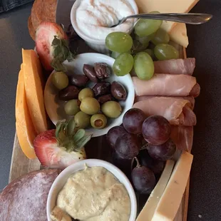 a platter of cheese, grapes, and meats