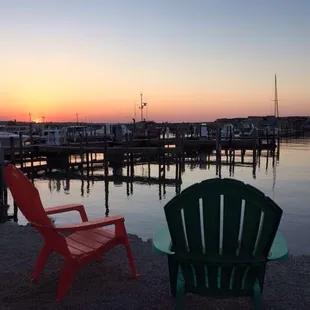 two lawn chairs facing the water