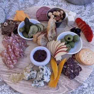 a platter of cheese, crackers, olives, and crackers
