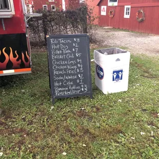 a chalkboard sign and a trash can