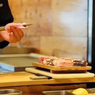 a chef cutting up meat on a cutting board