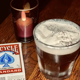 a glass of beer and a packet of playing cards