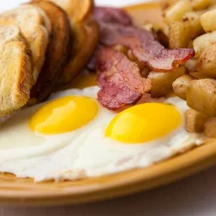 a plate of eggs, potatoes and toast