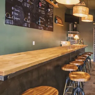 a bar with stools and a chalkboard