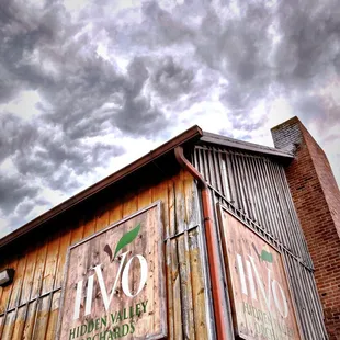a wooden building with a cloudy sky