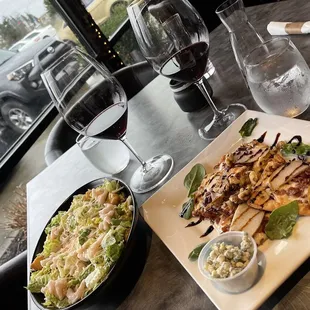 a plate of salad and a glass of wine