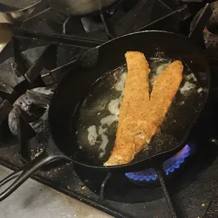 ows two fish frying in a frying pan
