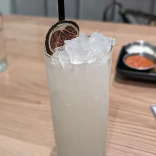 a close up of a drink with ice and a slice of lime